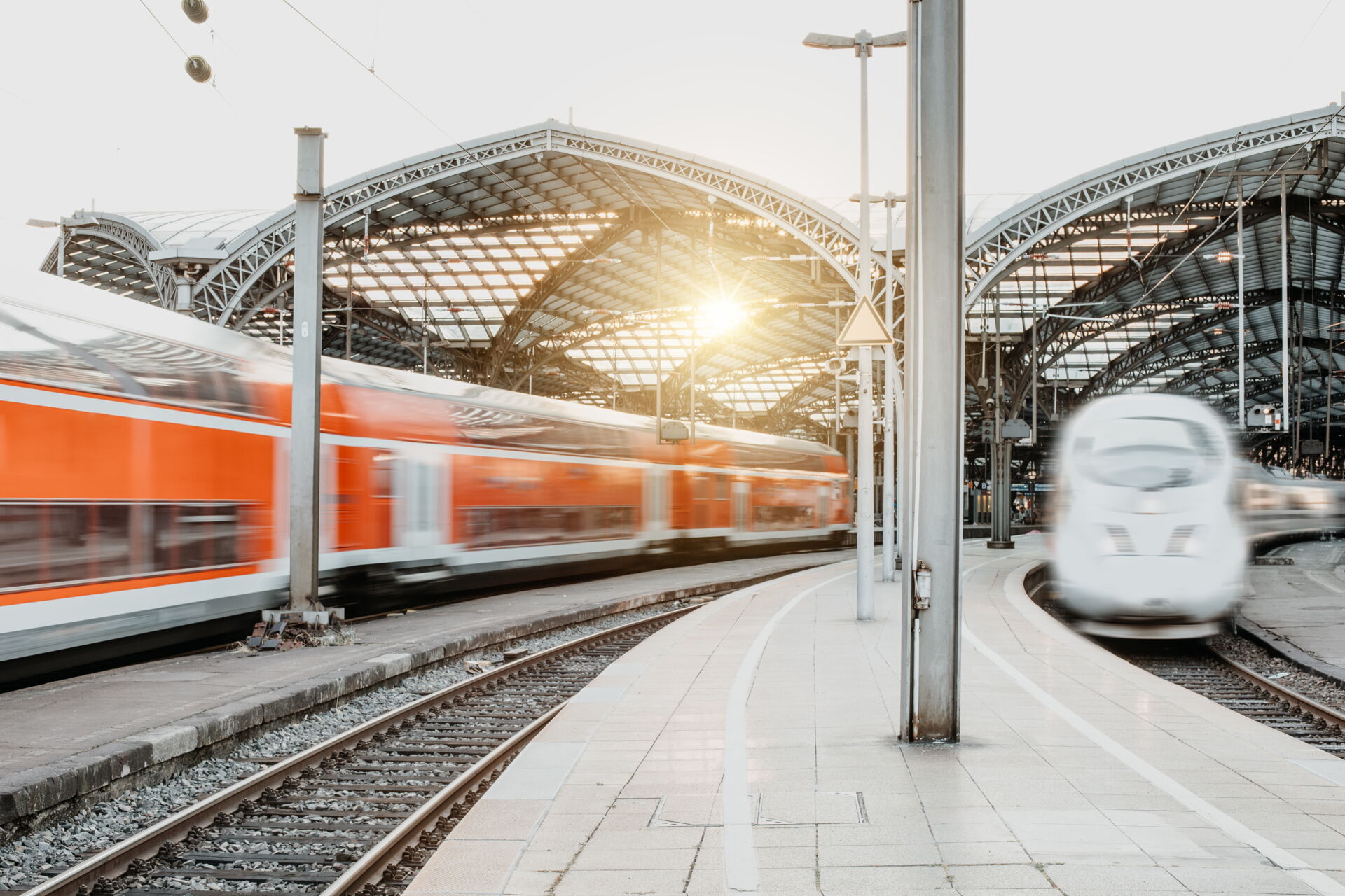 Aufnahme eines Bahnhofes mit zwei Zügen und die Sonne scheint durch ein Fenster