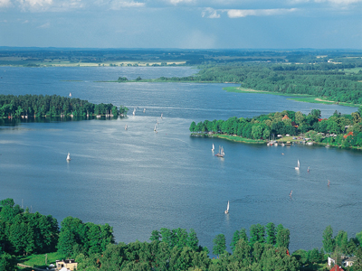11-tägige Radtour durch die Masuren Luftaufnahme von einem See mit mehreren Segelbooten drauf und Bäumen am Ufer