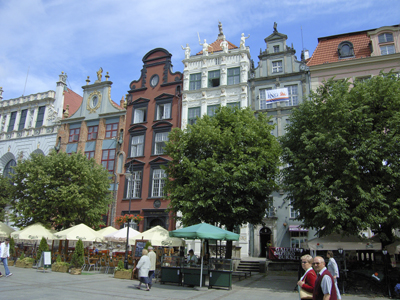Radtour von Danzig über Ermland nach Masuren Bunte Bauwerke und davor sind Bäume und mehrere Restaurants in Danzig