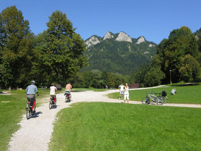 Radtour Dunajec Drei Personen fahren mit dem Fagrrad auf einem Fahrradweg in Dunajec zwischen Bergen und Wäldern