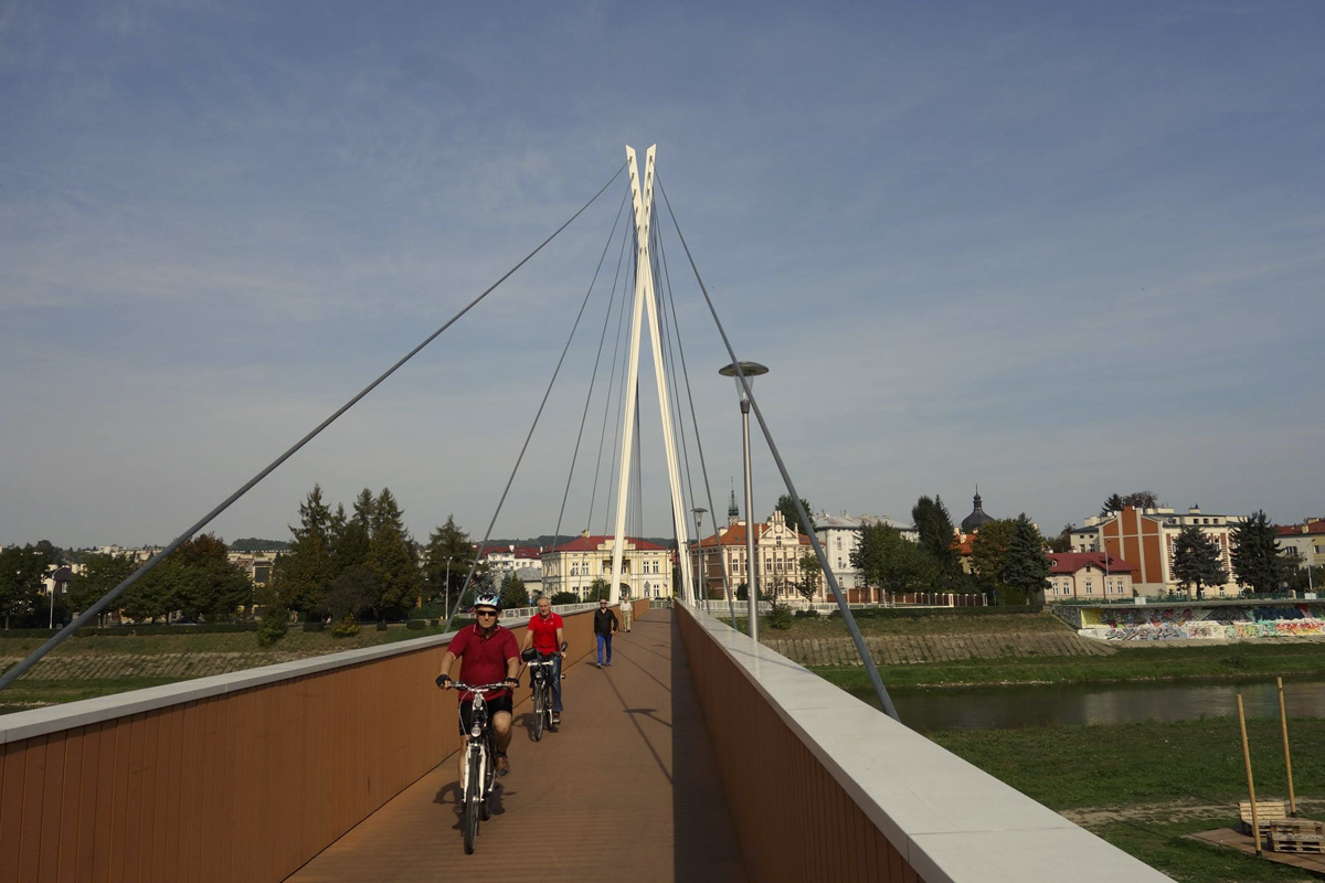 Mehrere Personen laufen beziehungsweise fahren über die Przemysl Fahrradbrücke