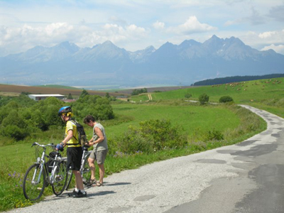 Radtour von Krakau nach Budapest Zwei Frauen halten das Fahrrad und schauen in die Natur. Im Hintergrund ist ein Berg
