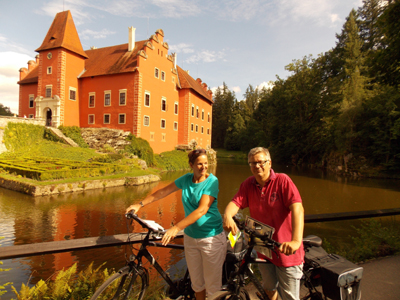 Radtour von Prag nach Wien Zwei Personen stehen vor einem Schloss und schauen in die Kamera