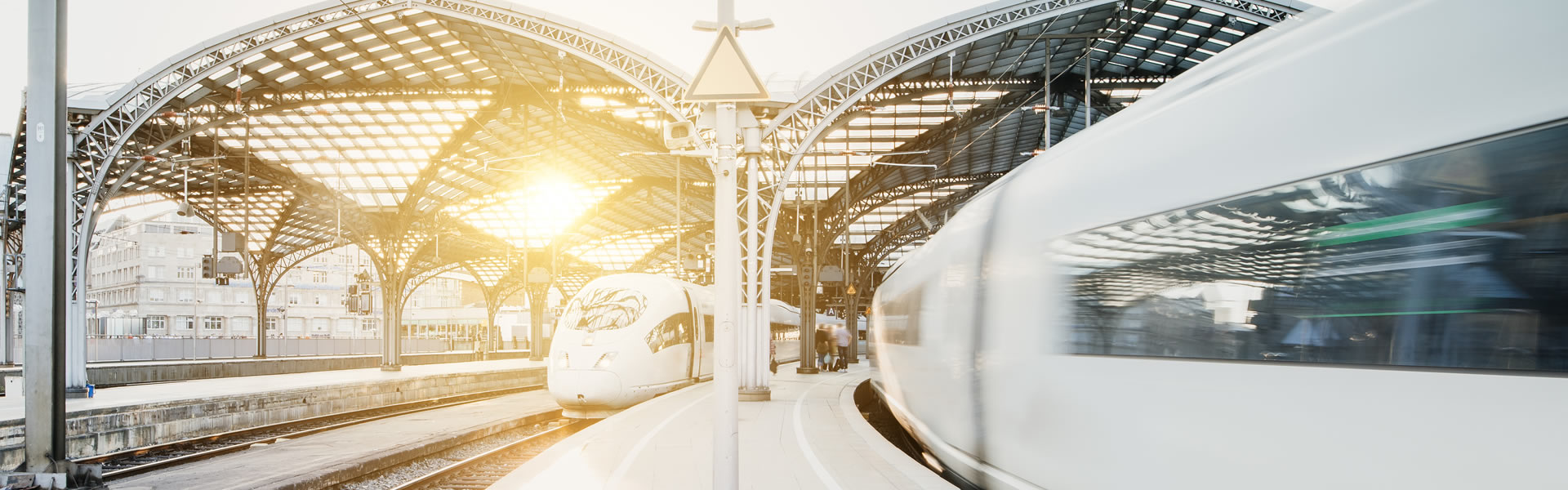 Aufnahme eines Bahnhofes mit zwei Zügen und die Sonne scheint durch ein Fenster