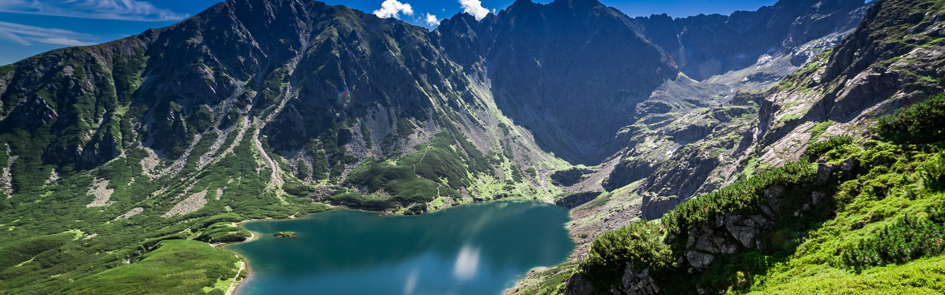 Eine Berglandschaft mit Wanderwegen in Polen und vor den Bergen ist ein riesiger See